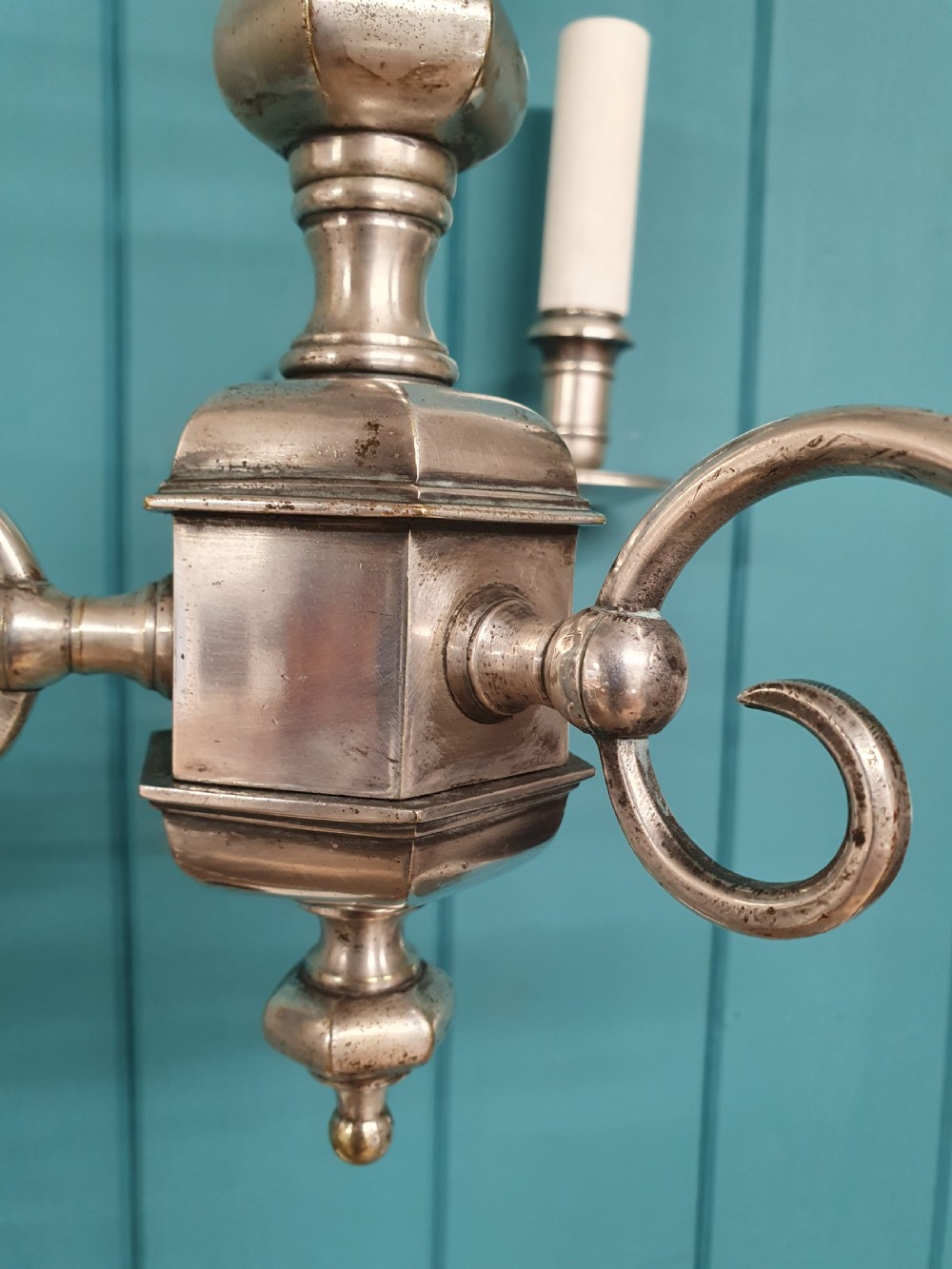 A pair of early twentieth-century nickel silver chandeliers, each featuring a central baluster stem, three scrolling arms, and candle-style lamp holders. View VIII