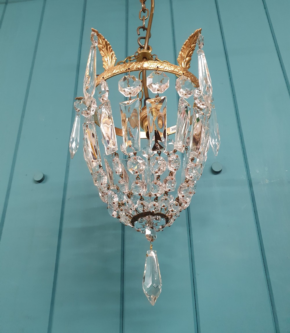 An eight-inch antique pouch-style chandelier featuring a decorative brass rim, cascading faceted glass prisms forming a basket shape, and a hanging crystal drop. View II