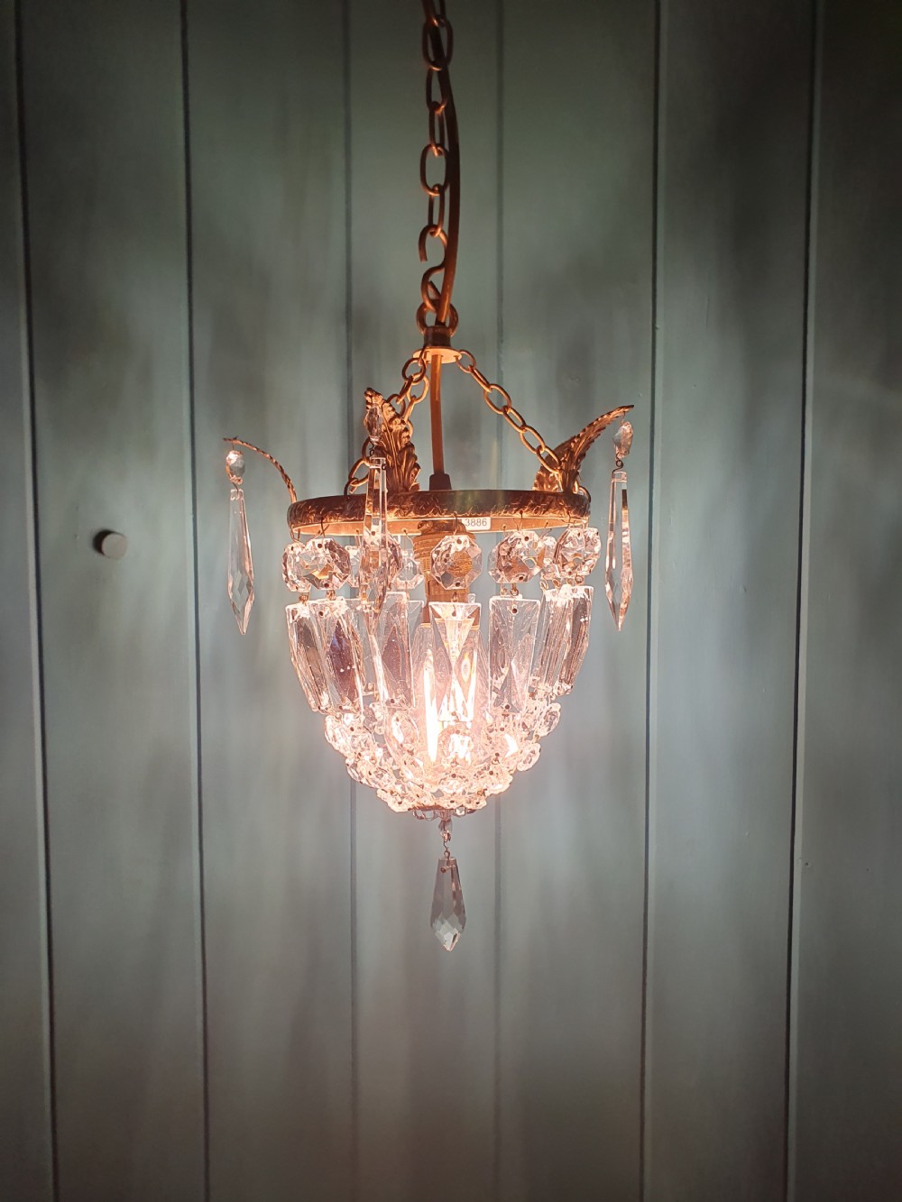 An eight-inch antique pouch-style chandelier featuring a decorative brass rim, cascading faceted glass prisms forming a basket shape, and a hanging crystal drop. View III
