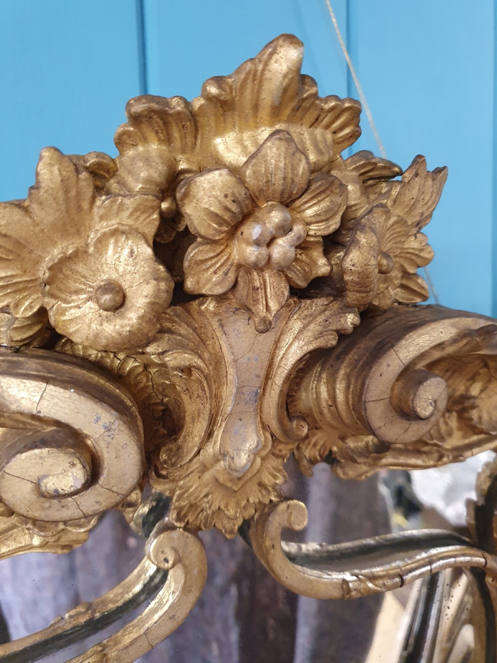 An ornate 19th-century Rococo style giltwood wall mirror featuring carved floral accents, scrollwork, and a decorative inner frame boundary. View III