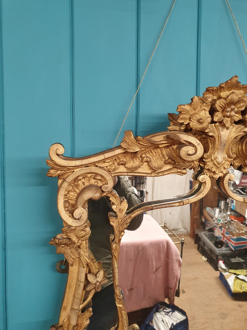 An ornate 19th-century Rococo style giltwood wall mirror featuring carved floral accents, scrollwork, and a decorative inner frame boundary. View IX