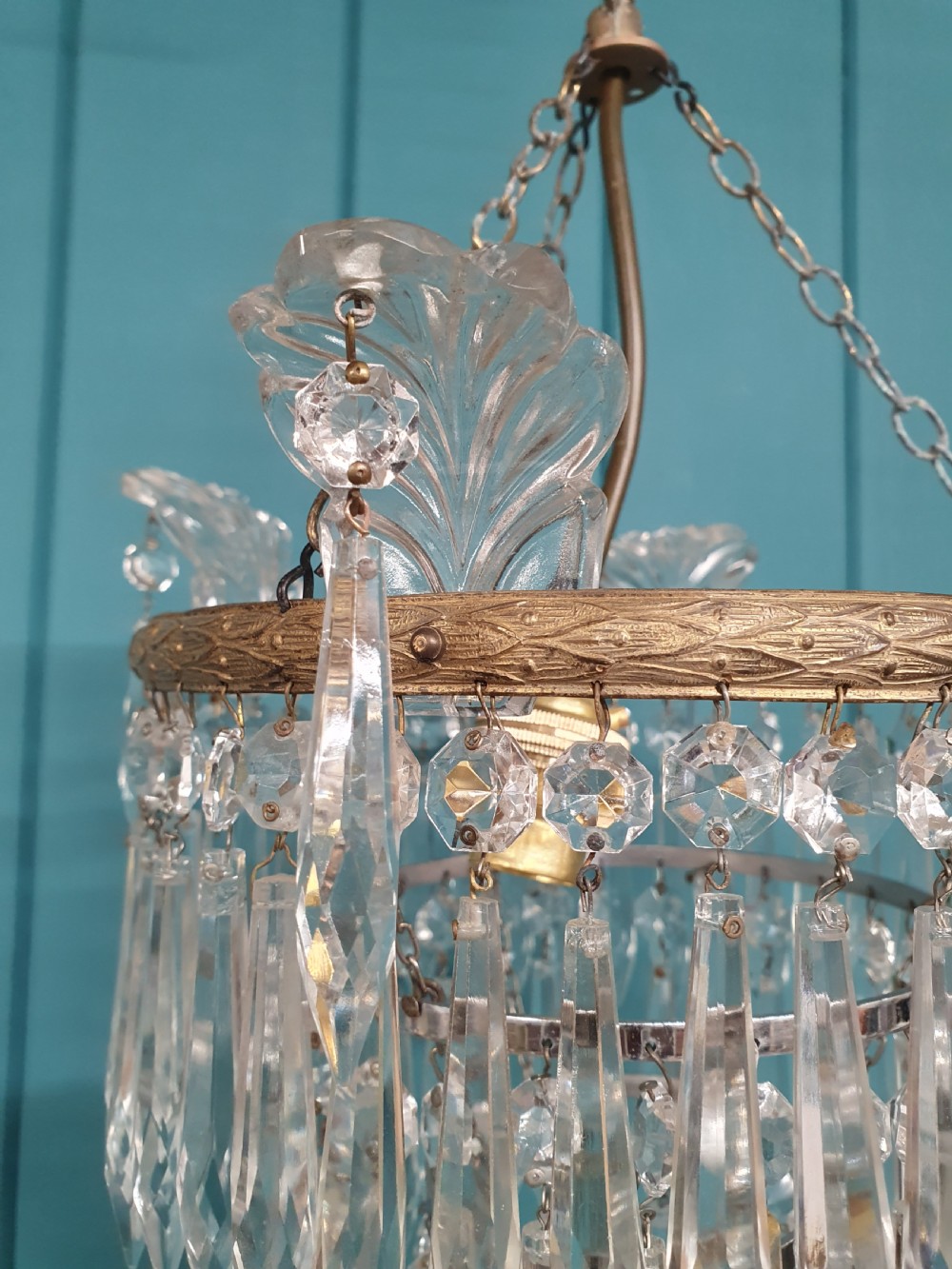 A pair of matching eleven-inch ceiling chandeliers featuring brass frames suspended with tiers of clear cut crystal glass spikes and drops. View V