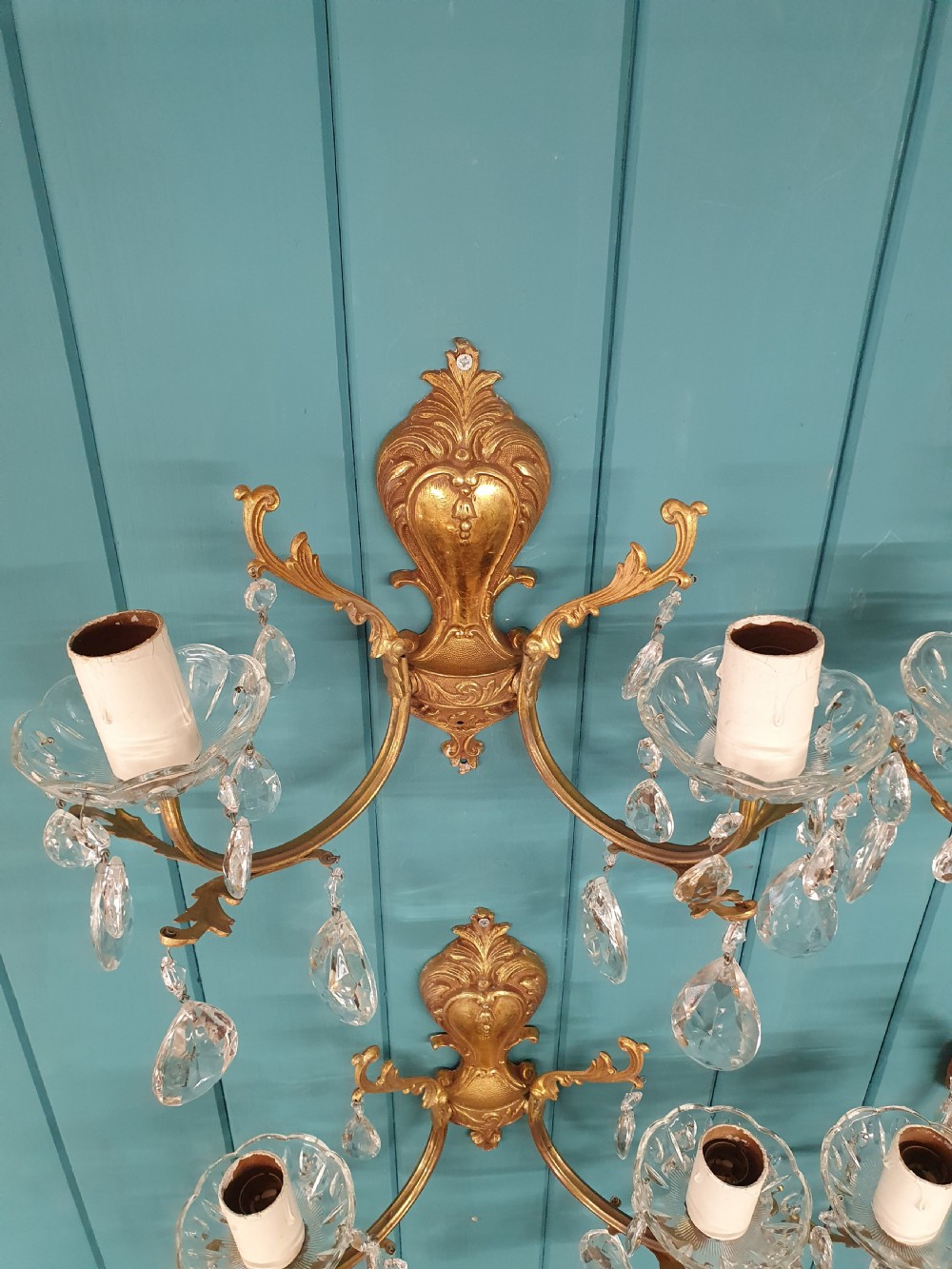 A set of four early 20th-century French Rococo revival gilt brass twin-arm wall sconces decorated with cut crystal glass droplets. View III