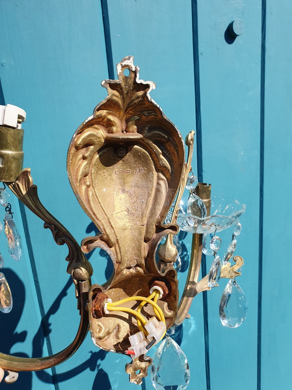A set of four early 20th-century French Rococo revival gilt brass twin-arm wall sconces decorated with cut crystal glass droplets. View VI