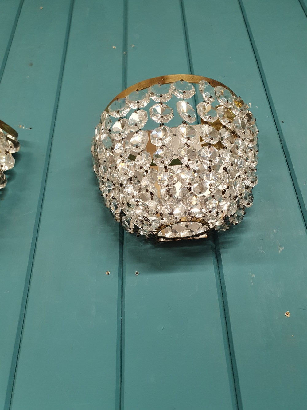 A pair of antique crystal bag wall lights featuring semi-circular pouch frames filled with faceted glass crystal beads below brass bands. View III