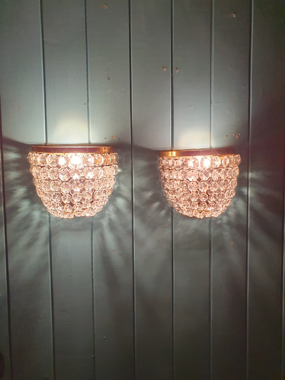 A pair of antique crystal bag wall lights featuring semi-circular pouch frames filled with faceted glass crystal beads below brass bands. View IV
