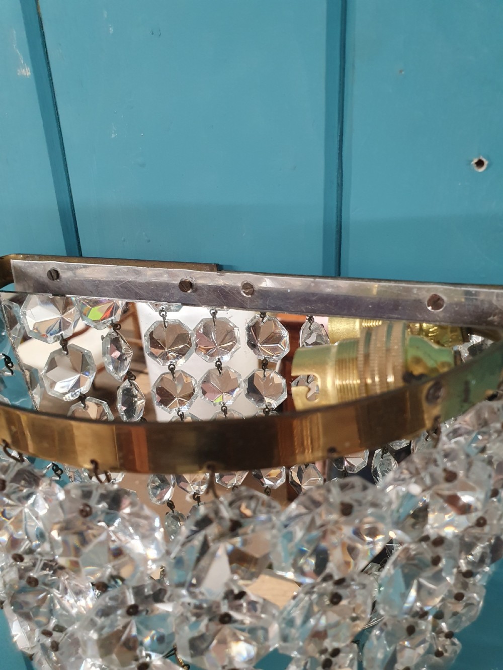 A pair of antique crystal bag wall lights featuring semi-circular pouch frames filled with faceted glass crystal beads below brass bands. View VI