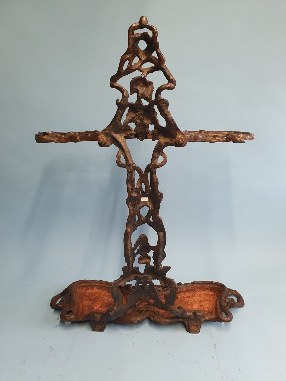 A Victorian cast iron stick stand featuring naturalistic branch and foliage decoration with a drip tray base. View V