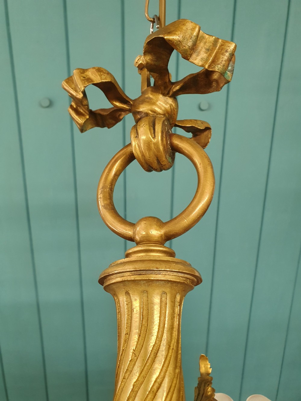 A cast brass three-arm chandelier featuring cherub head reliefs on a central fluted body and floral frosted glass shades. View VIII