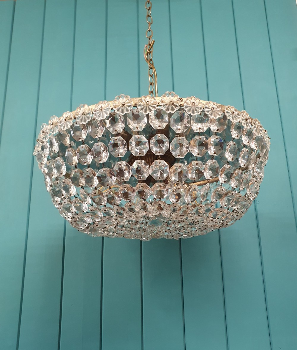 A circular ceiling chandelier featuring suspended octagonal cut glass crystal beads in a basket shape with decorative glass rosettes along the upper rim.