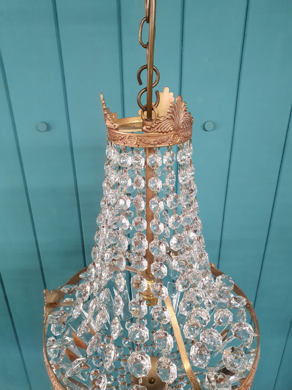 A cut glass crystal tent and bag chandelier featuring concentric tiers of glass beads suspended from a chased brass rim. View II