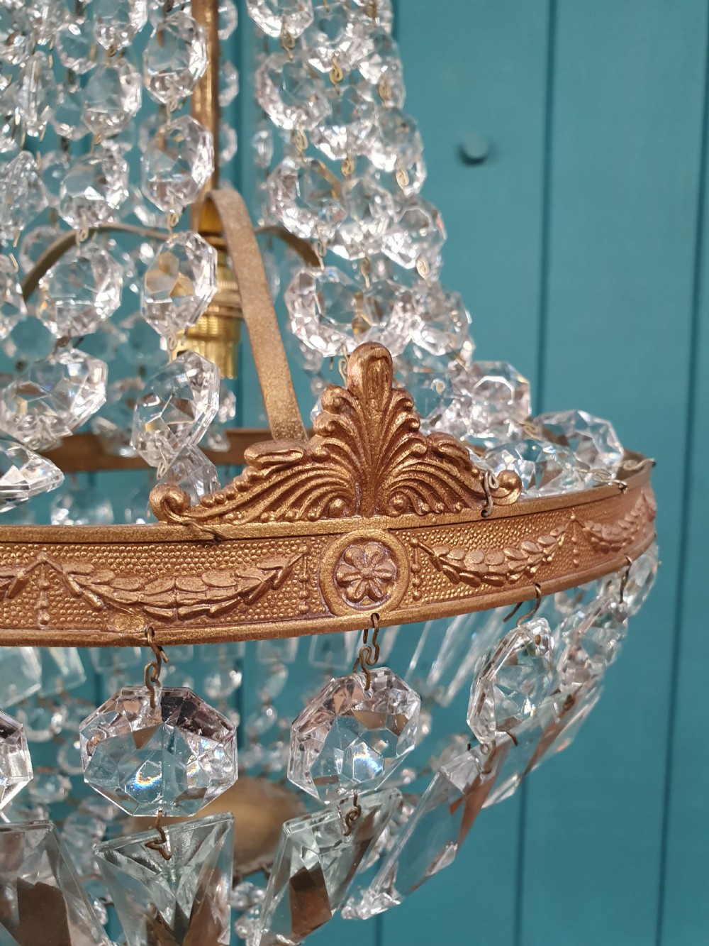 A cut glass crystal tent and bag chandelier featuring concentric tiers of glass beads suspended from a chased brass rim. View V