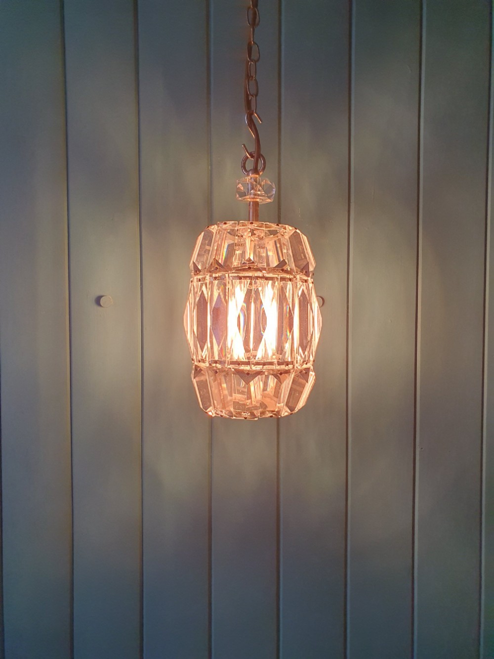 An early 20th-century small barrel-shaped crystal prism chandelier suspended by a brass link chain. View IV