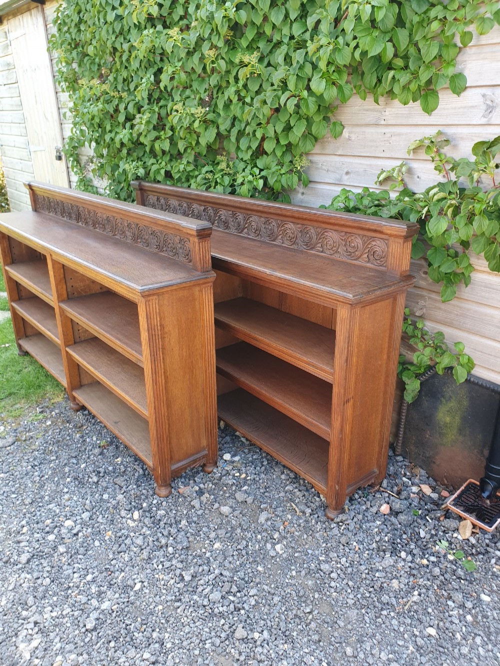 A pair of 19th-century low oak bookcases featuring carved scrollwork back galleries and open twin-bay shelving. View IX