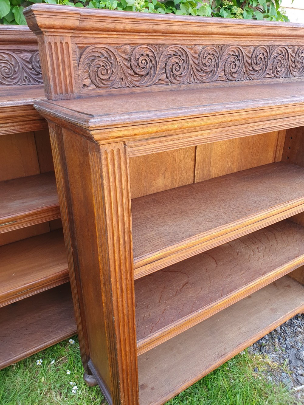 A pair of 19th-century low oak bookcases featuring carved scrollwork back galleries and open twin-bay shelving. View XII
