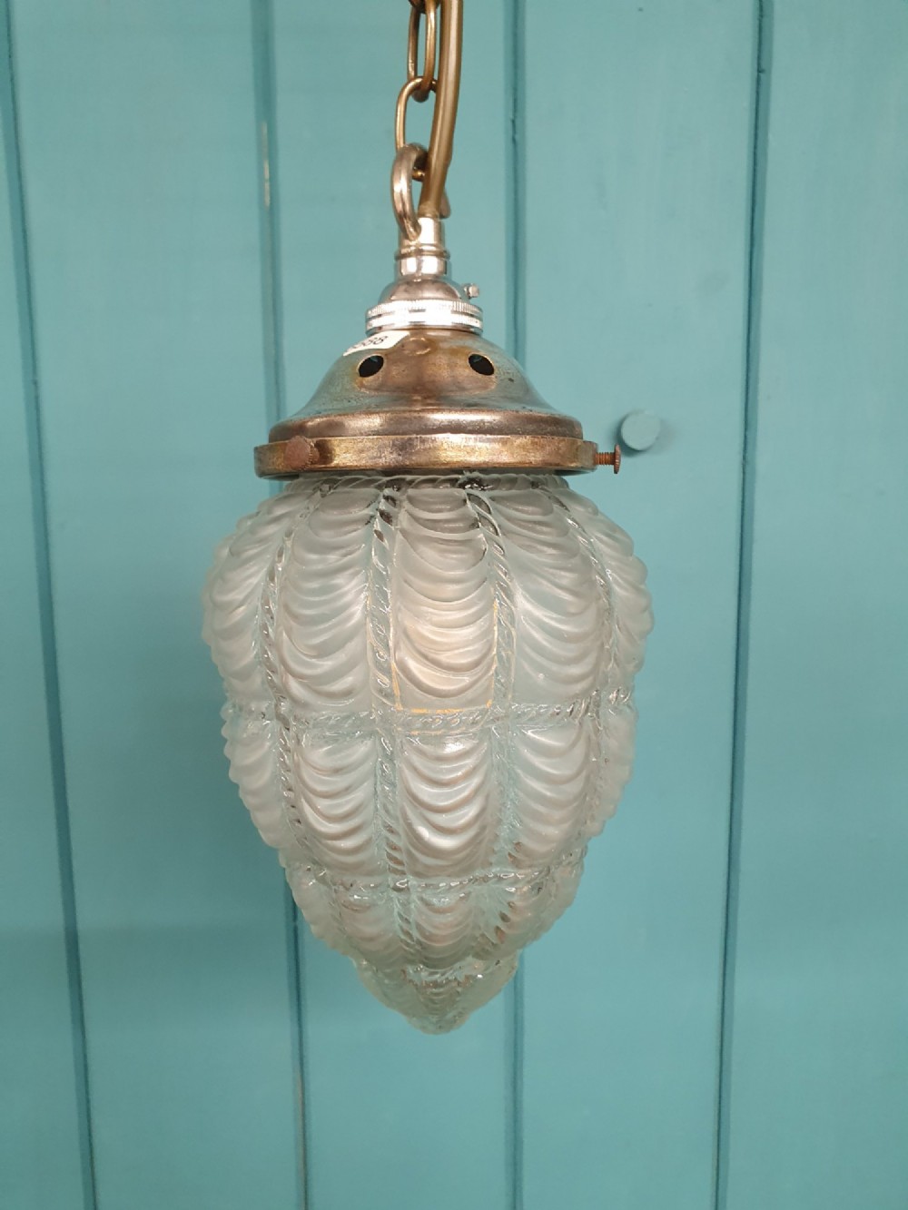 An antique moulded glass pendant light shade with a swag design hanging from a brass gallery and link chain. View IV
