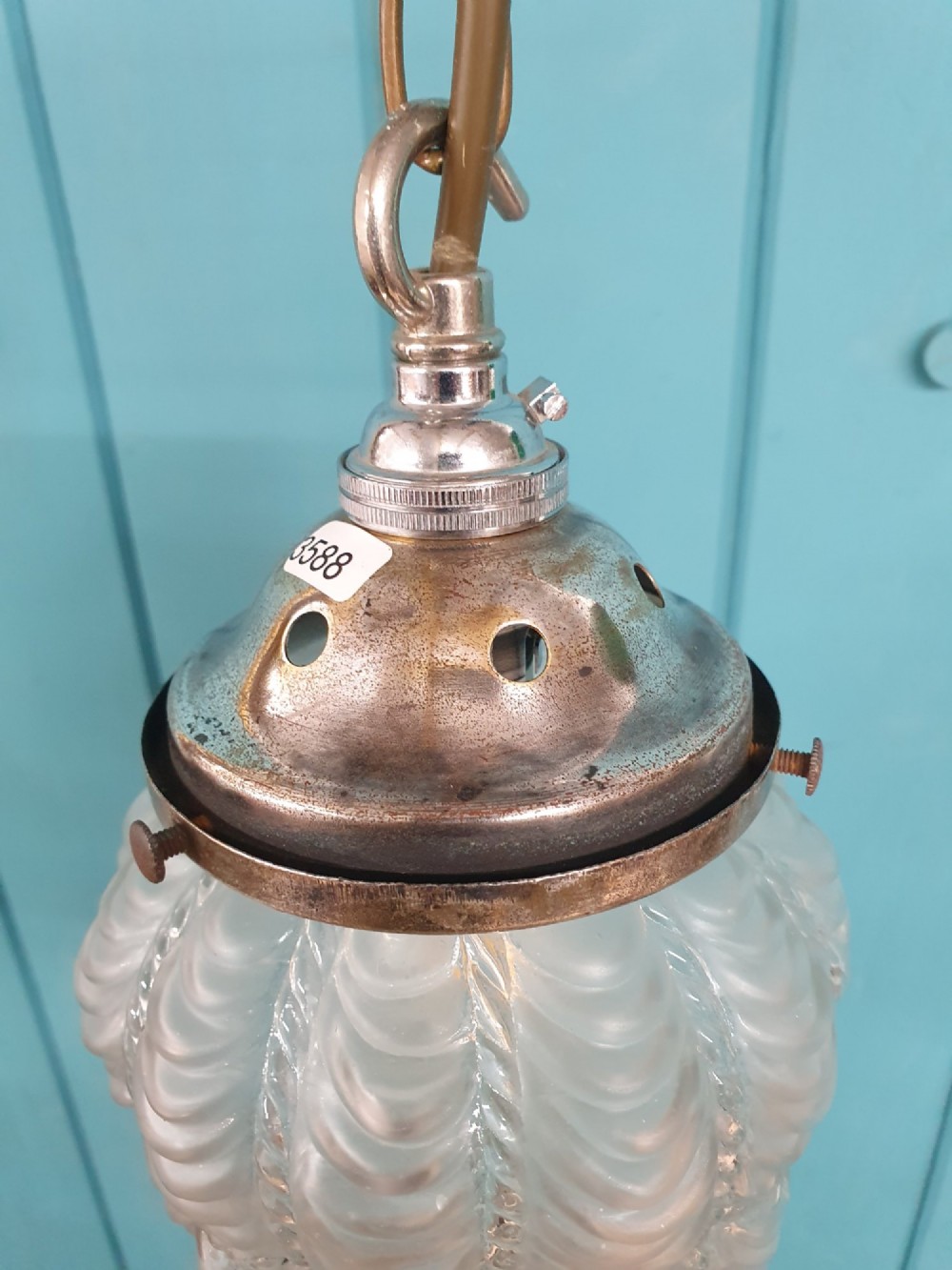 An antique moulded glass pendant light shade with a swag design hanging from a brass gallery and link chain. View VI