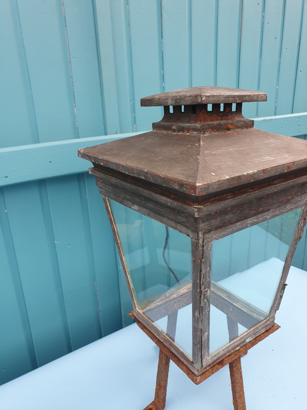A Victorian weather-worn copper gas lantern converted for electric use, featuring clear glass panels and a stepped pyramidal top cowl supported by an iron mounting base. View III