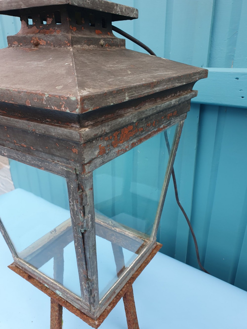 A Victorian weather-worn copper gas lantern converted for electric use, featuring clear glass panels and a stepped pyramidal top cowl supported by an iron mounting base. View IV