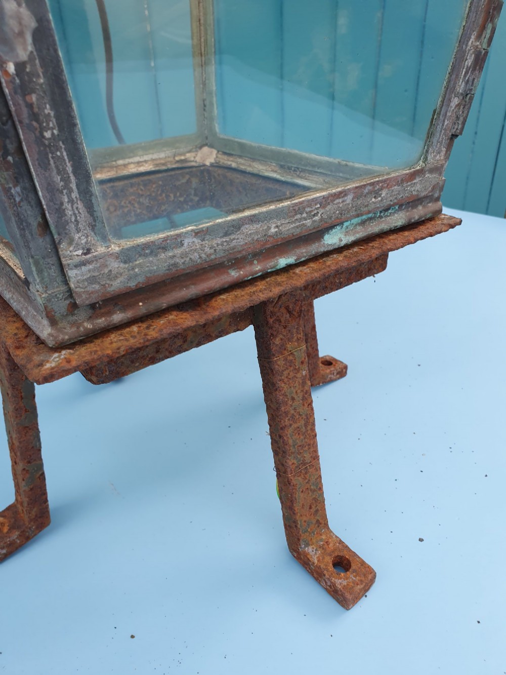 A Victorian weather-worn copper gas lantern converted for electric use, featuring clear glass panels and a stepped pyramidal top cowl supported by an iron mounting base. View V