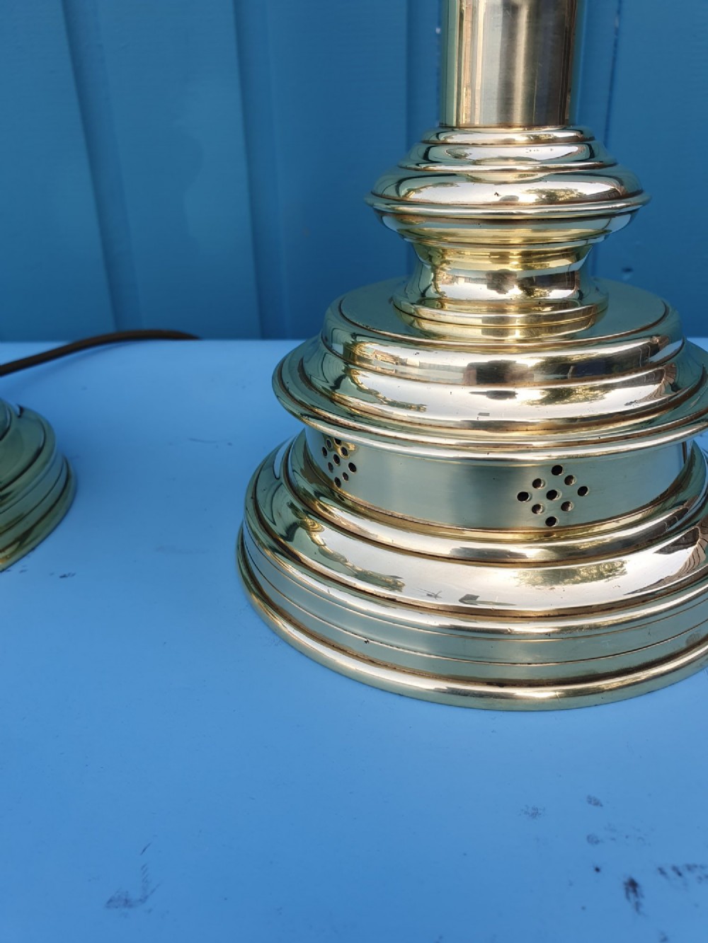 A pair of turned brass column table lamps topped with cylindrical bright pink fabric shades. View III