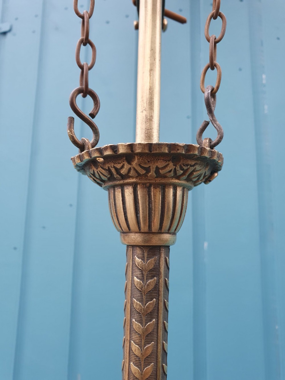 An antique brass three-arm rise and fall chandelier with fluted clear glass shades and scrolled metalwork detailing. View XI