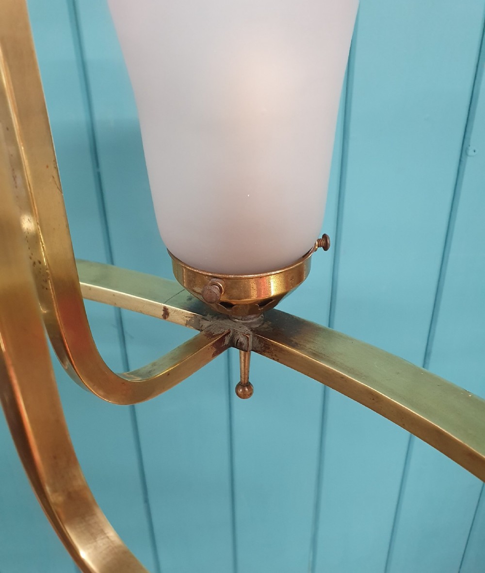 An Art Deco brass four-light chandelier featuring a circular brass frame suspending four tulip-shaped pink frosted glass shades with ruffled rims. View IV
