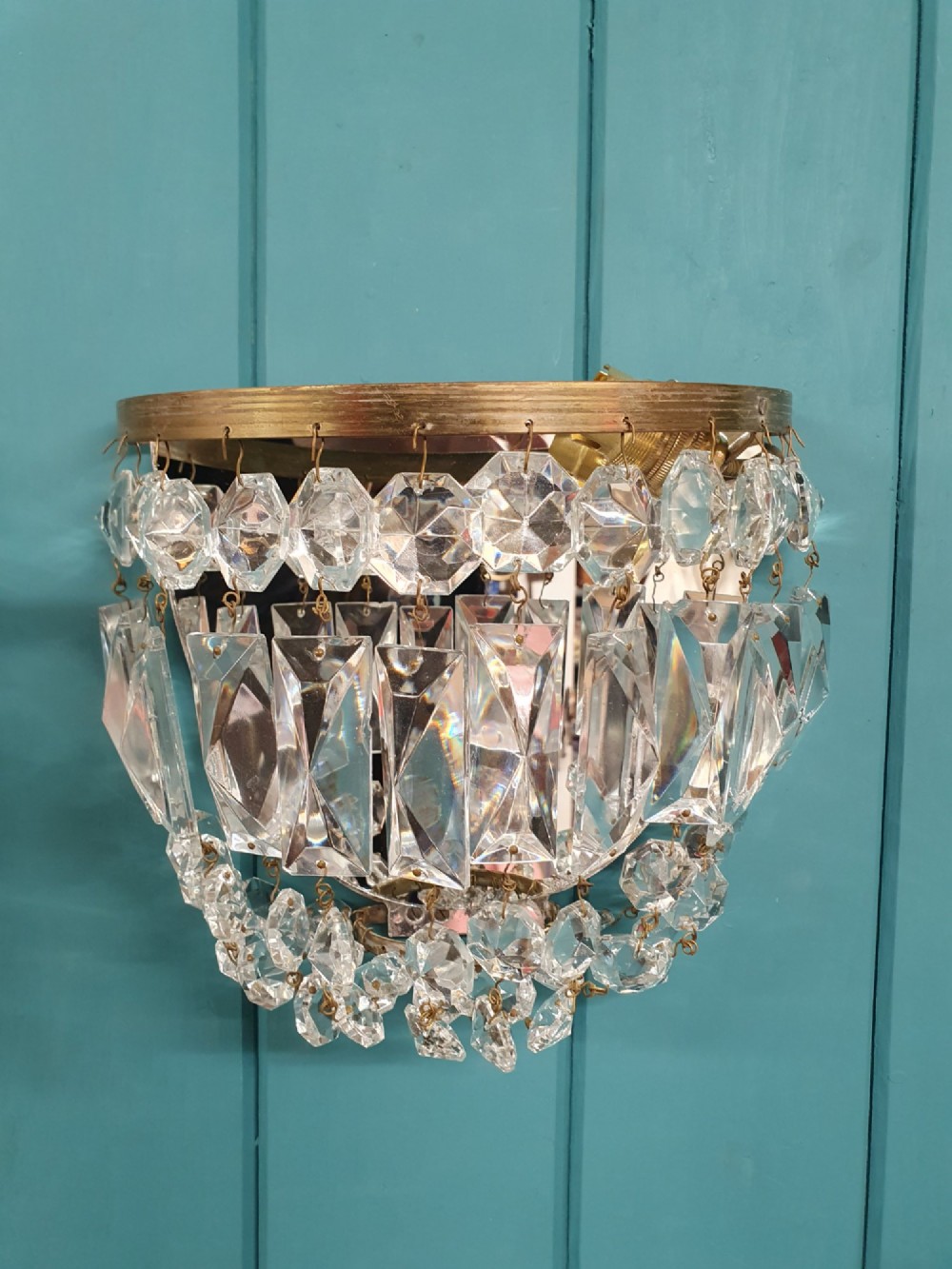 A pair of early 20th-century wall sconces featuring semi-circular brass frames hung with tiered cut-crystal prisms. View III