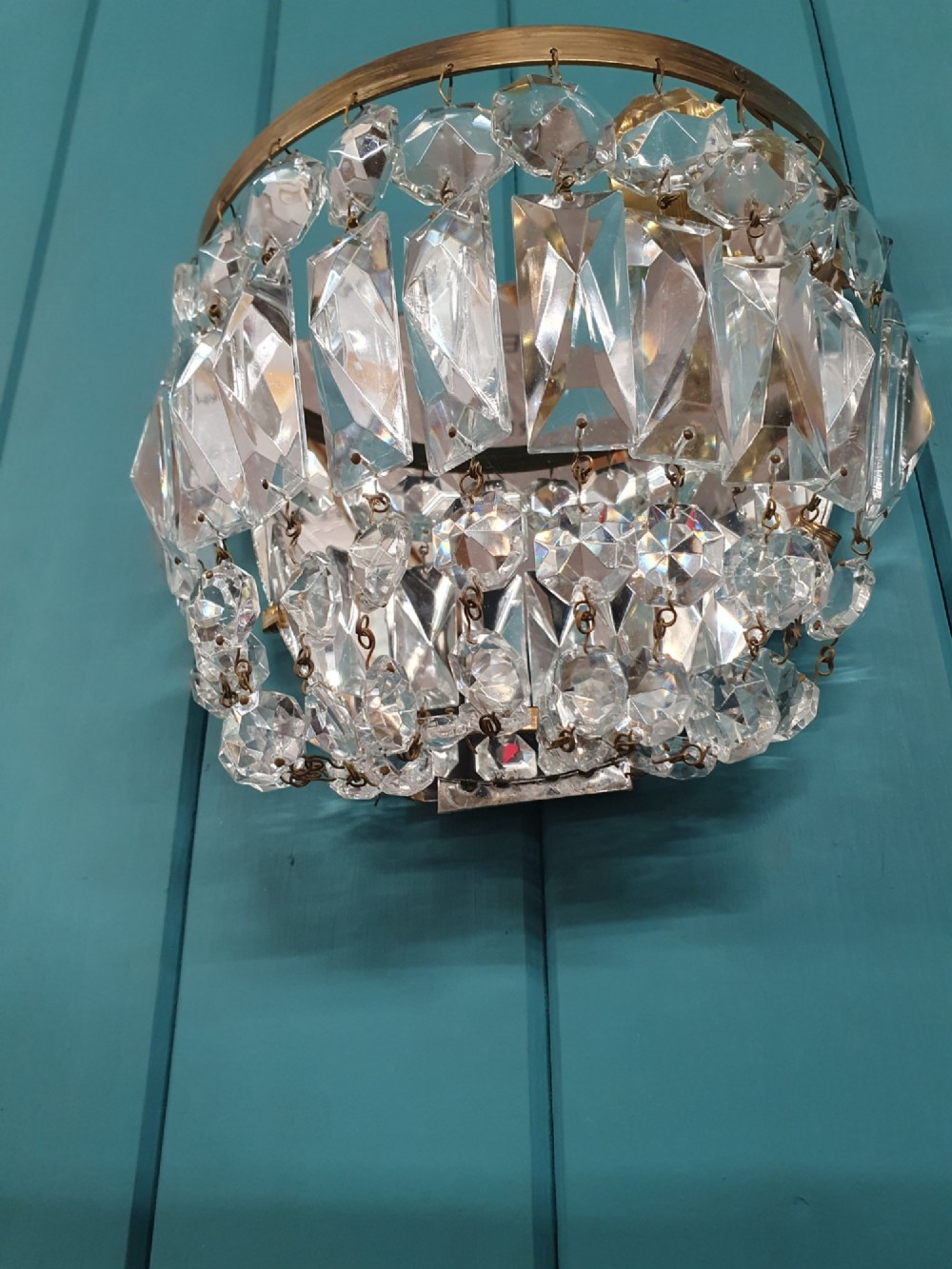 A pair of early 20th-century wall sconces featuring semi-circular brass frames hung with tiered cut-crystal prisms. View IV