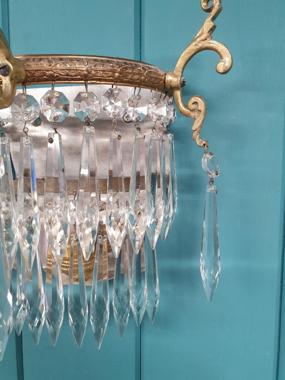 A pair of antique gilt brass wall lights featuring cascading concentric tiers of pointed crystal glass prisms. View II