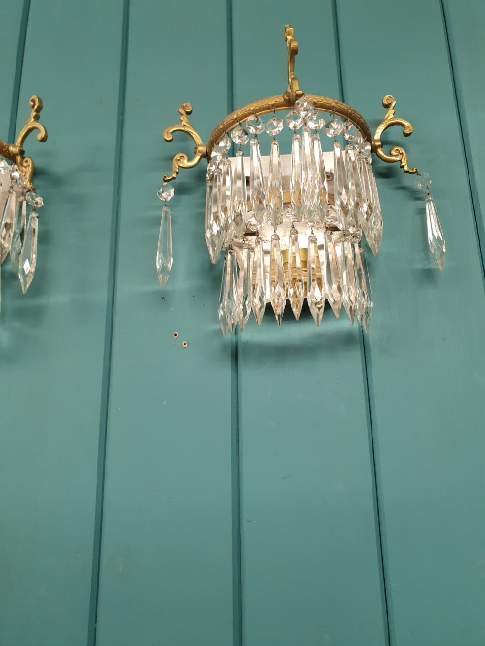 A pair of antique gilt brass wall lights featuring cascading concentric tiers of pointed crystal glass prisms. View III