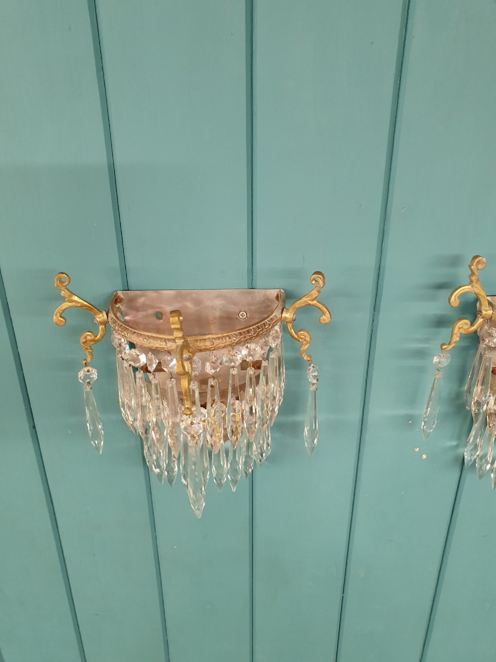 A pair of antique gilt brass wall lights featuring cascading concentric tiers of pointed crystal glass prisms. View IV