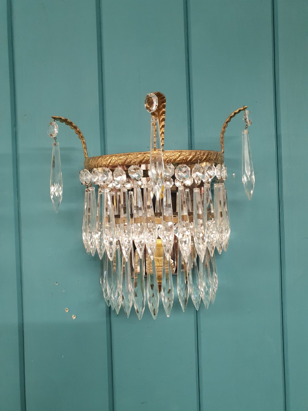 A pair of antique gilt brass wall lights adorned with cascading tiers of crystal spikes and glass drops. View II