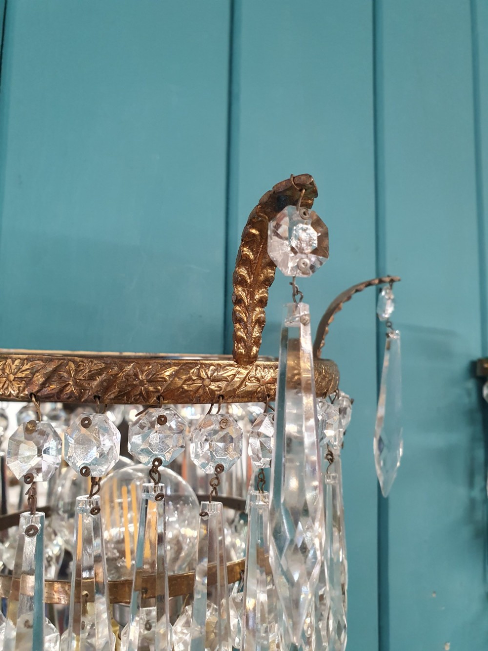 A pair of antique gilt brass wall lights adorned with cascading tiers of crystal spikes and glass drops. View III