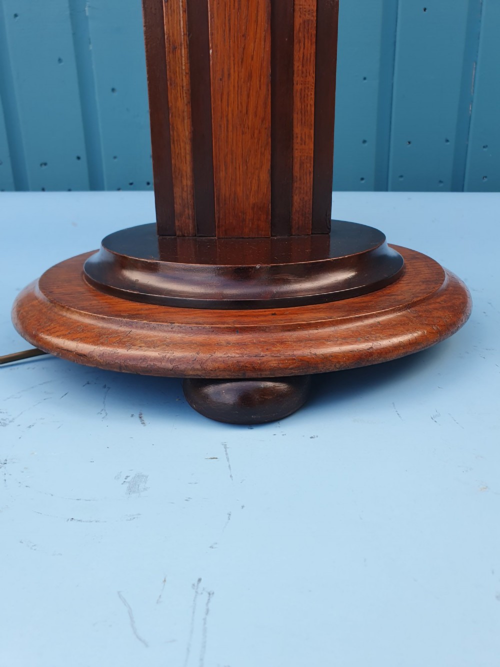 An Art Deco wooden standard lamp featuring a stepped skyscraper column design set upon a circular turned base with a brass light fitting. View III