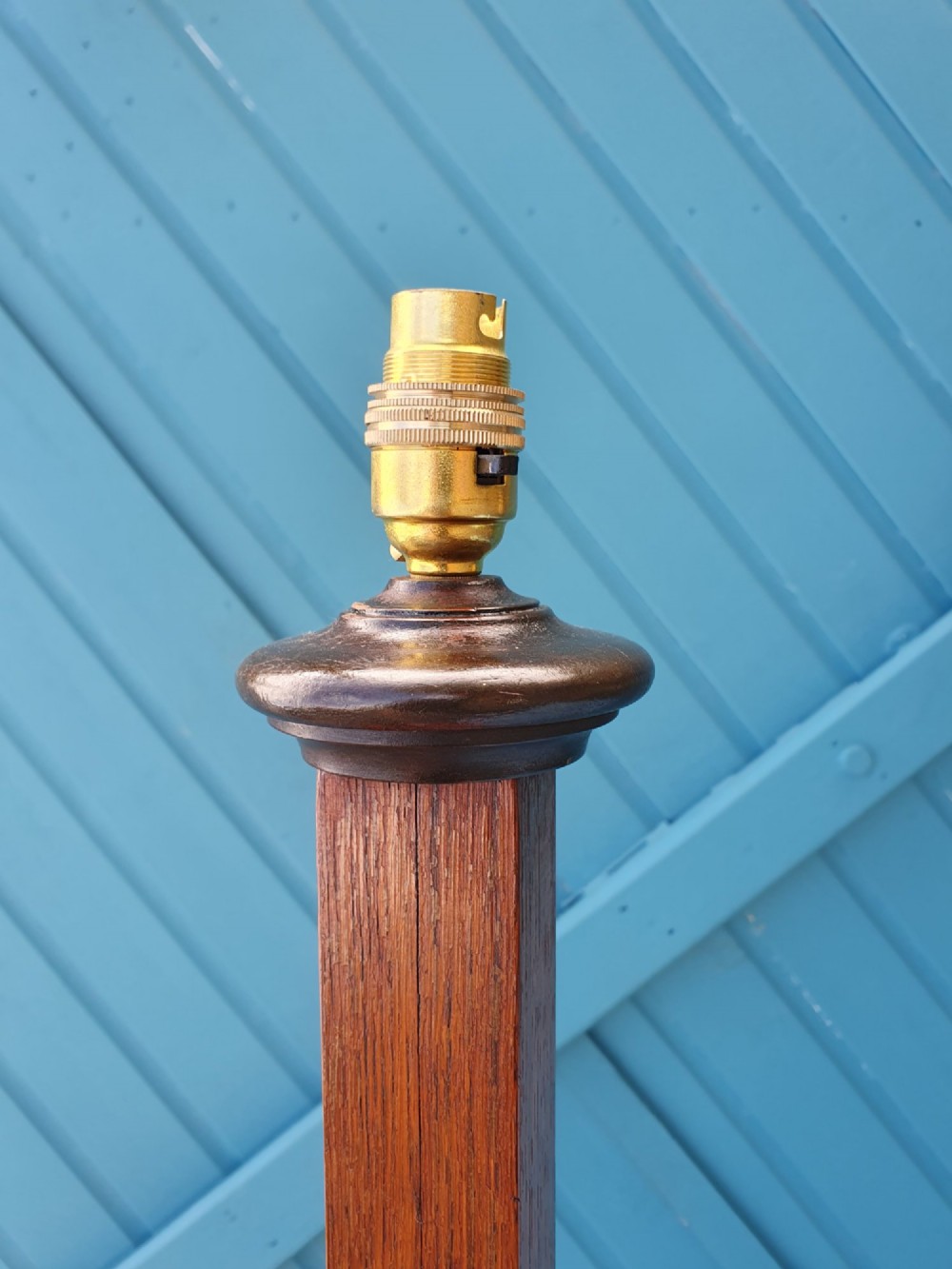 An Art Deco wooden standard lamp featuring a stepped skyscraper column design set upon a circular turned base with a brass light fitting. View IV