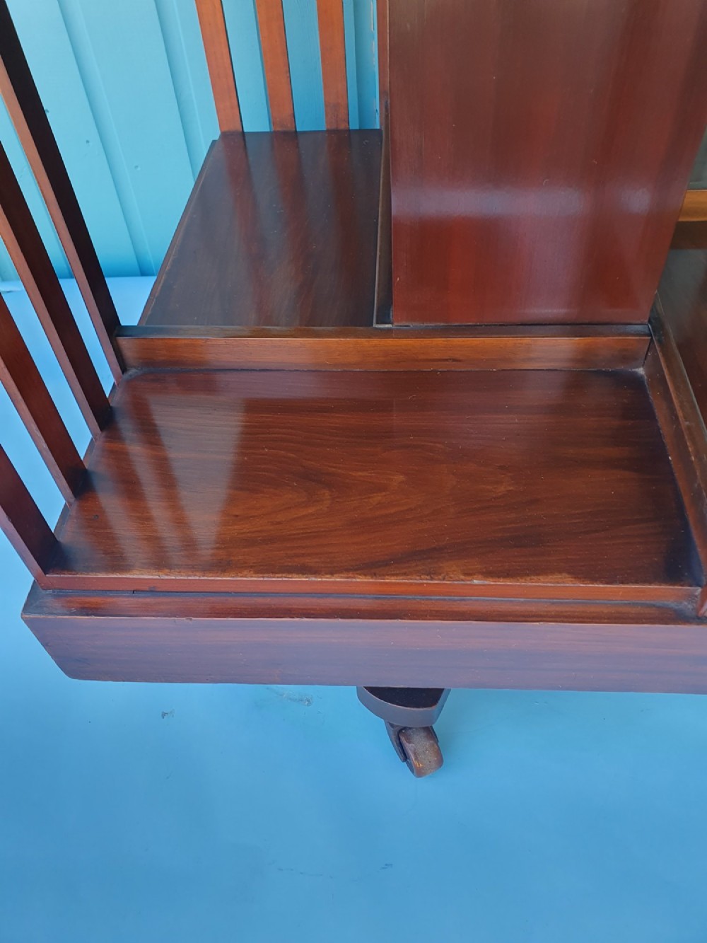 A four-tiered Victorian walnut revolving bookcase featuring vertical slatted sides, open shelf compartments, and a square moulded top on castors. View VII