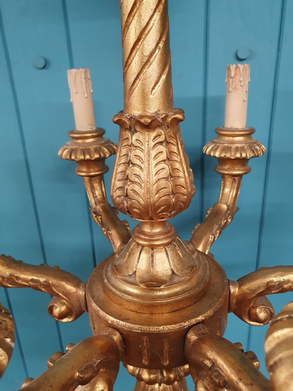 A Victorian circa 1890 six-arm giltwood chandelier featuring carved scroll arms, fluted details, and faux candle sleeves. View II