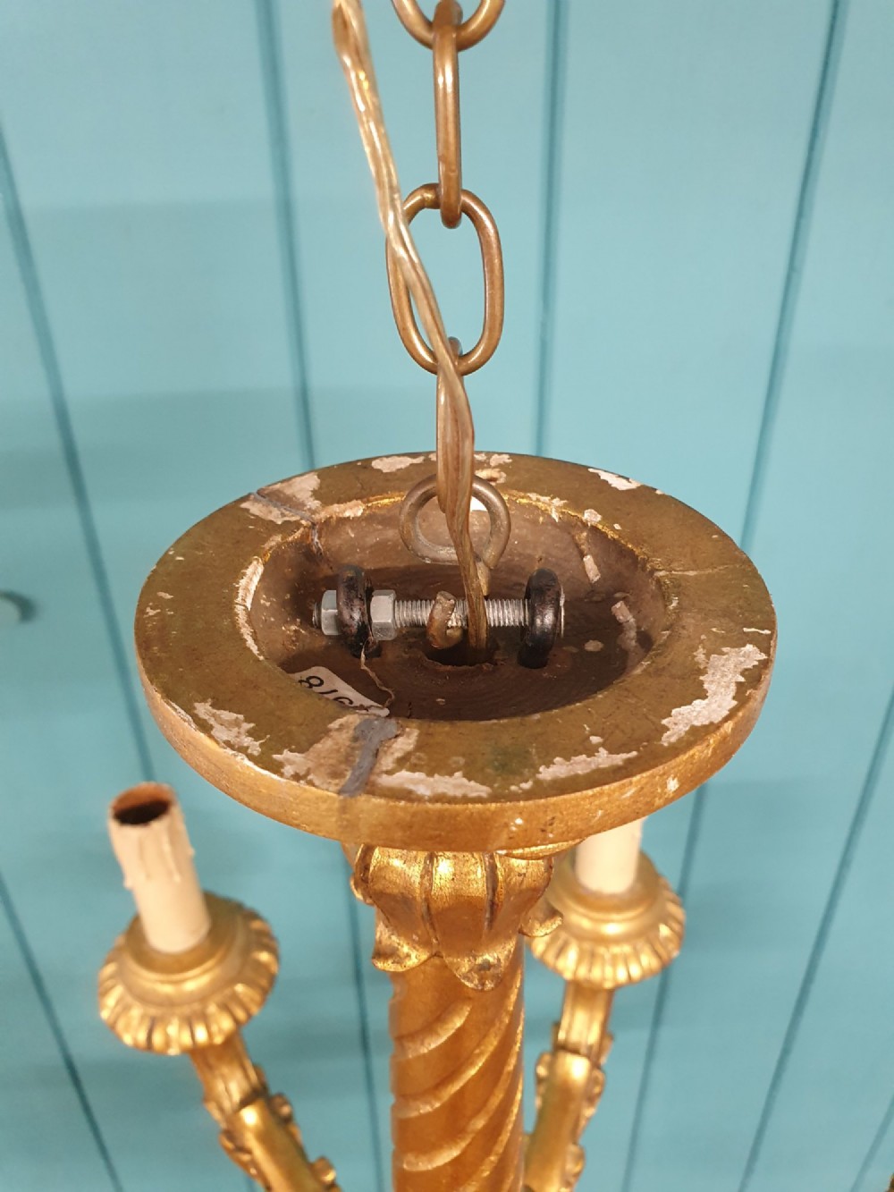 A Victorian circa 1890 six-arm giltwood chandelier featuring carved scroll arms, fluted details, and faux candle sleeves. View III