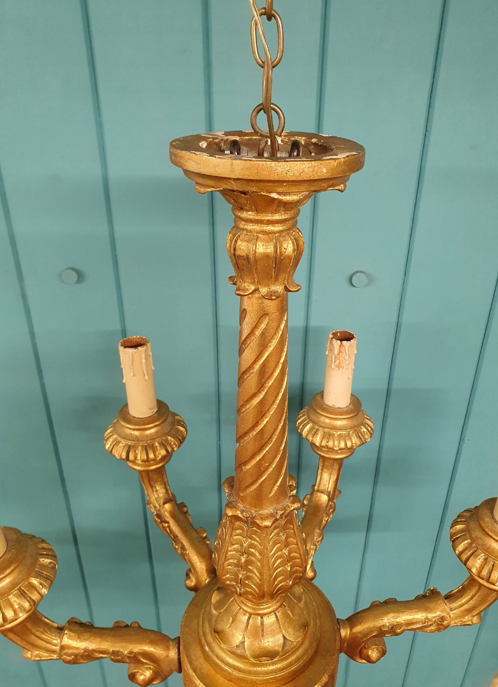 A Victorian circa 1890 six-arm giltwood chandelier featuring carved scroll arms, fluted details, and faux candle sleeves. View VIII