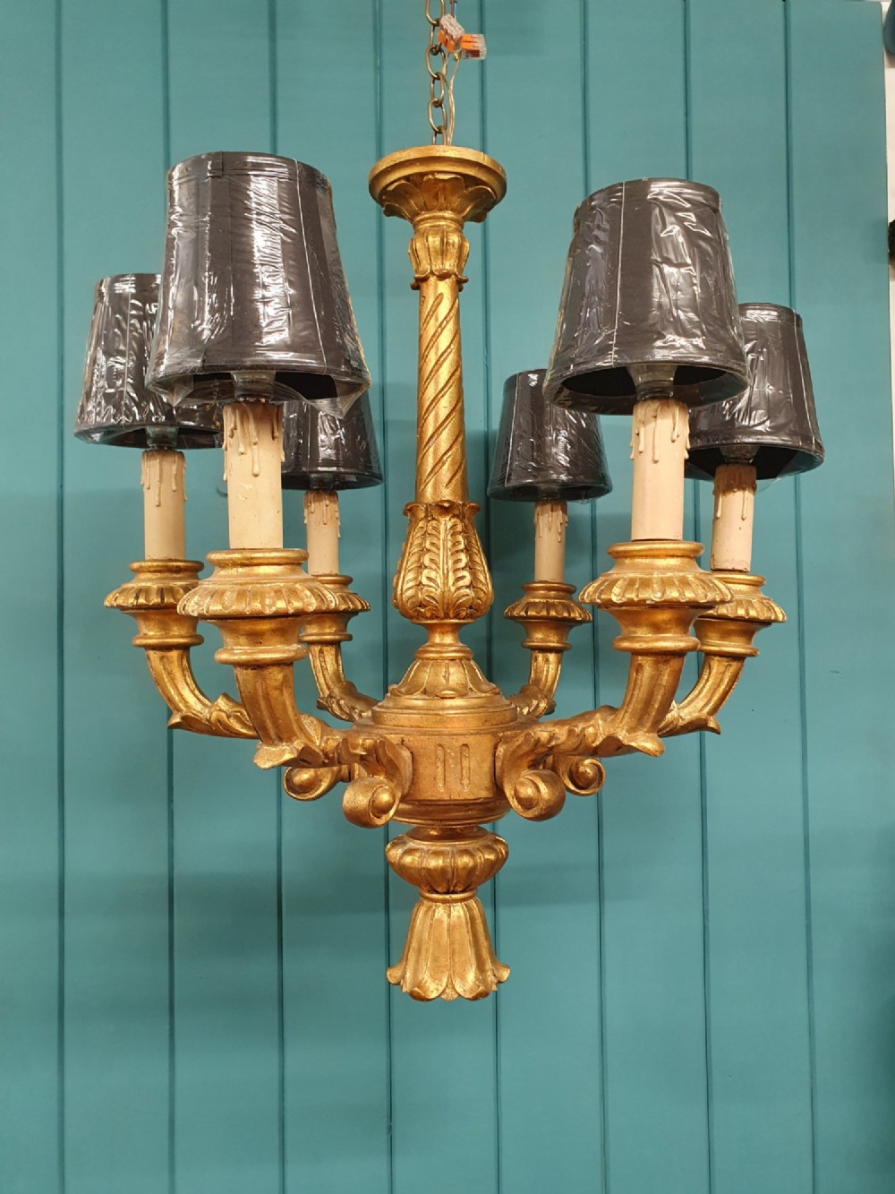 A Victorian circa 1890 six-arm giltwood chandelier featuring carved scroll arms, fluted details, and faux candle sleeves. View XI