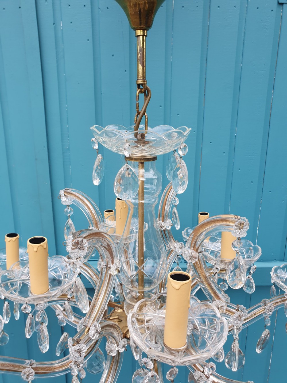 A matched pair of early 20th-century twelve-arm crystal chandeliers with faceted glass drops, curved arms, and brass mounts. View III