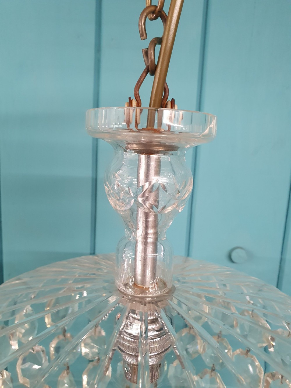 An early 20th-century dome-top chandelier with faceted crystal strands forming a rounded drop, suspended from a brass chain. View VII