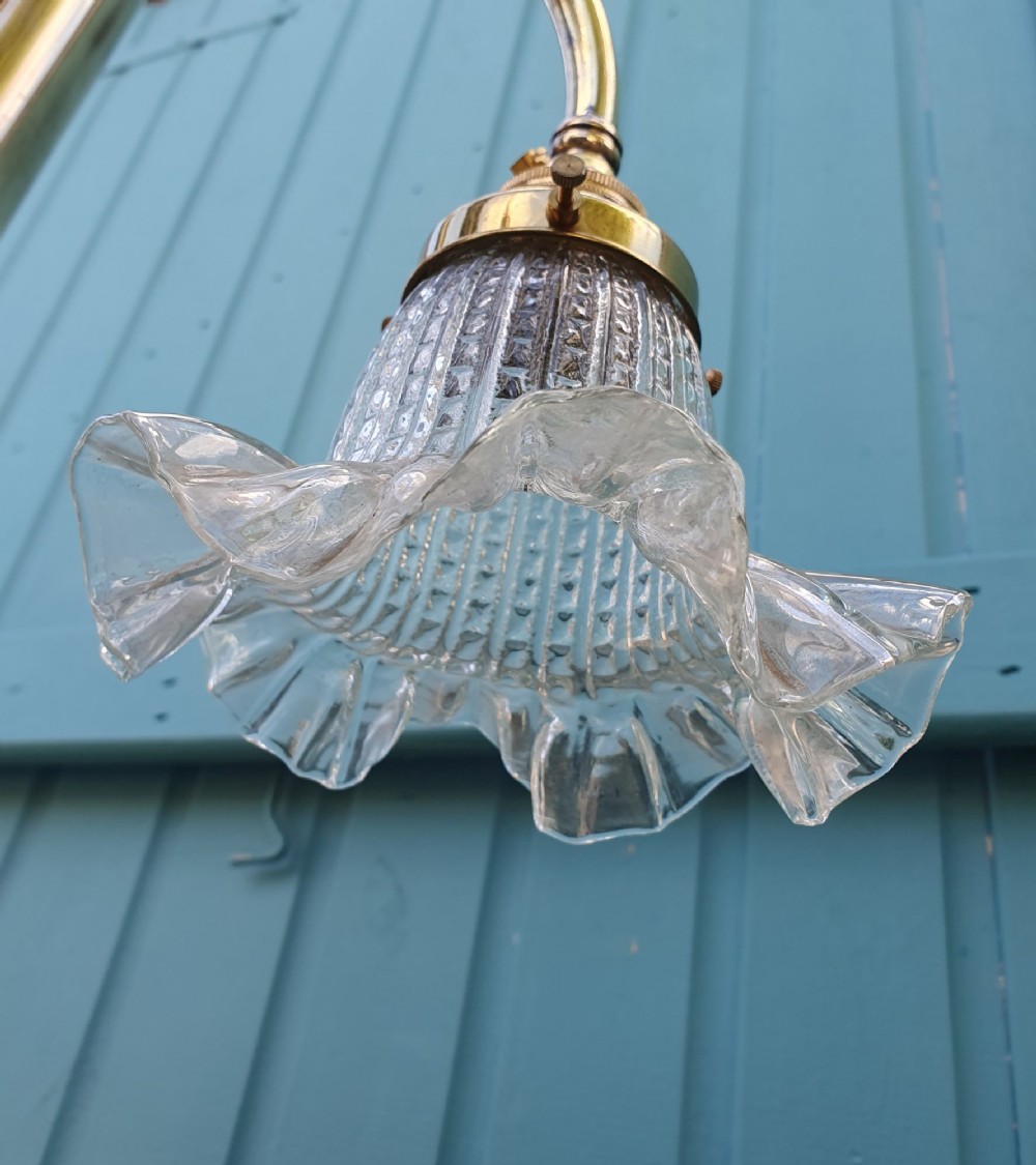 An antique brass four-arm rise and fall chandelier with curved arms, ruffled glass shades, and a counterweight pulley mechanism. View IV