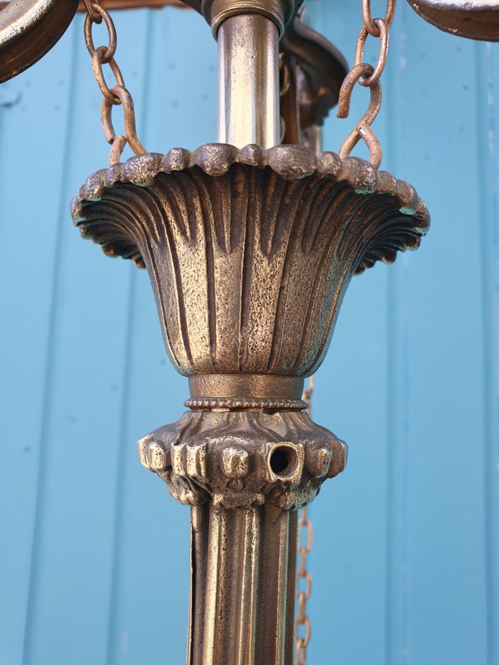 An antique brass four-arm rise and fall chandelier with curved arms, ruffled glass shades, and a counterweight pulley mechanism. View VII