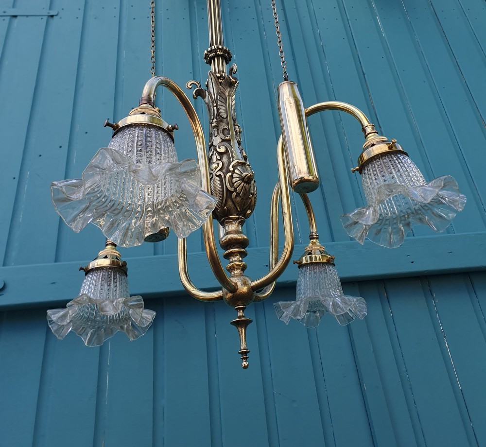 An antique brass four-arm rise and fall chandelier with curved arms, ruffled glass shades, and a counterweight pulley mechanism. View VIII