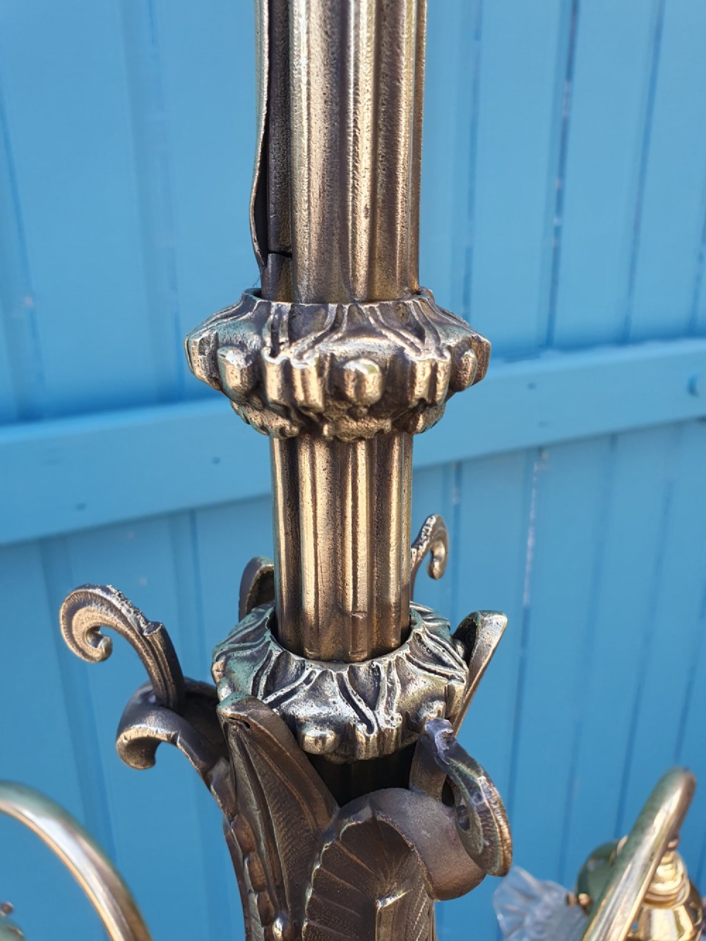 An antique brass four-arm rise and fall chandelier with curved arms, ruffled glass shades, and a counterweight pulley mechanism. View IX