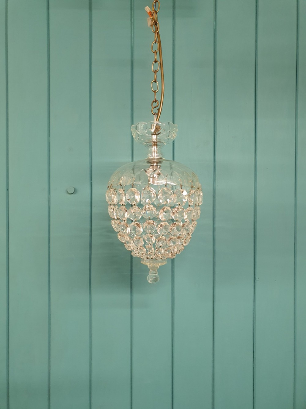 An early 20th-century crystal dome top pendant chandelier with faceted glass beads and a brass chain suspension.