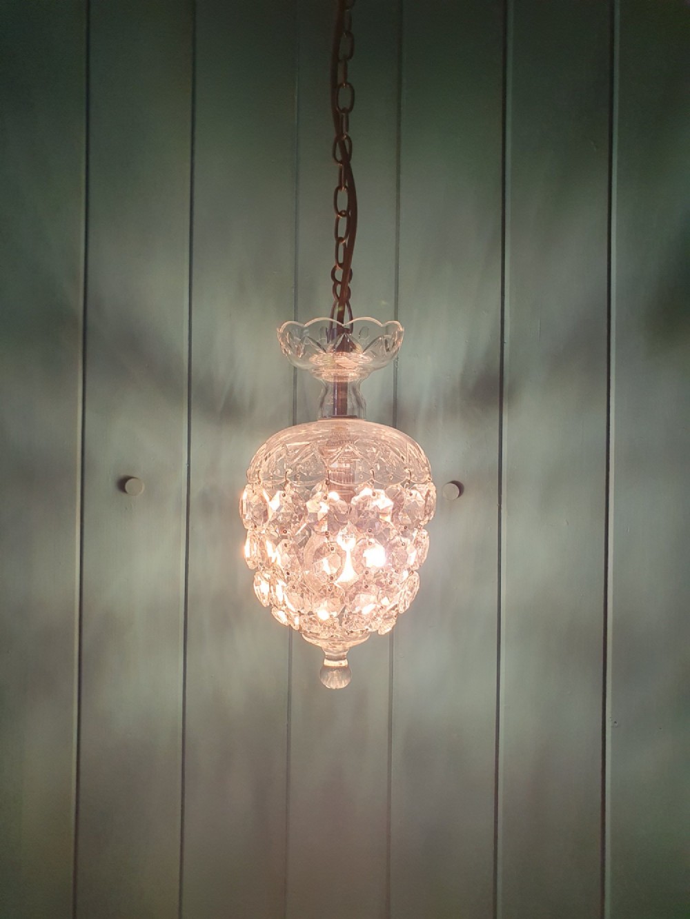 An early twentieth-century clear glass dome top chandelier featuring faceted crystal drops and a suspended hanging brass chain. View III