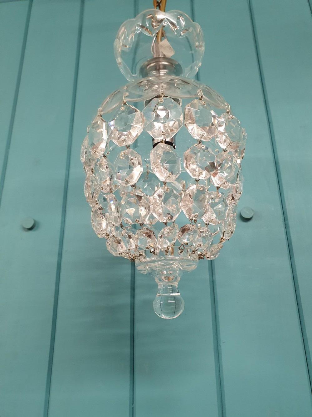 An early twentieth-century clear glass dome top chandelier featuring faceted crystal drops and a suspended hanging brass chain. View VI